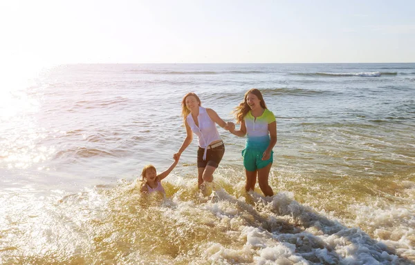 Família feliz brincando na costa do oceano . — Fotografia de Stock