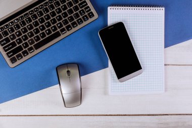 Laptop, akıllı telefon ve spiral notlu bilgisayar fareli modern ofis masası