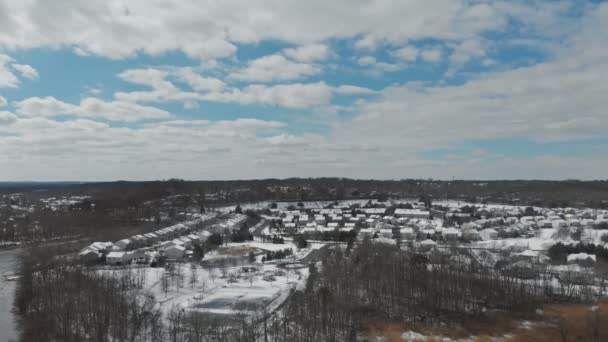 Запись беспилотника, летающего в окрестностях маленького городка, деревья покрытые снегом, дома — стоковое видео