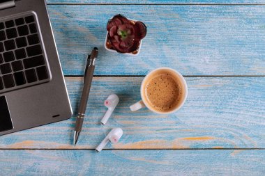 Elektronik cihazlar iş masasında dizüstü bilgisayarda, tablet kablosuz kulaklıklı kahve fincanı