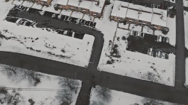 Oraș acoperit de zăpadă în imagini cu drone de iarnă care zboară jos peste un cartier suburbie — Videoclip de stoc