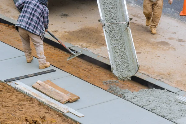 İnşaatta zemin döşemesi için beton kaldırımda çalışan işçiler