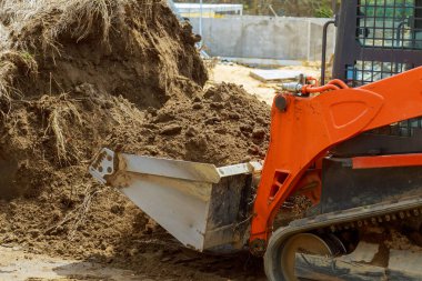 Buldozer toprak kazıcı inşaat ekipmanlarını taşıyor.