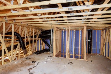 Tahta kirişler tavan arasını mineral yünü ve boru ısıtma sistemiyle yalıtıyor.