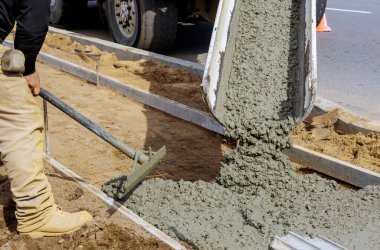 Beton karıştırıcı kamyondan kaldırımlı betona dökülüyor.