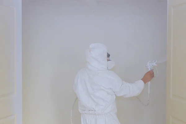 Hand with painting the door with a spray gun