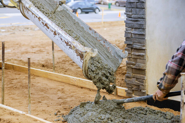 Бетономешалка цемента заливает цемент во время тротуара
