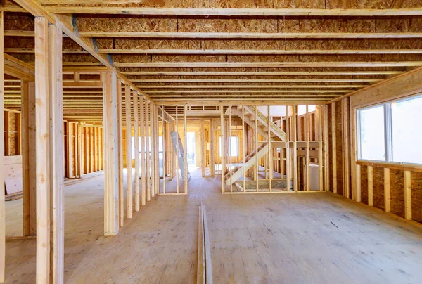 Building construction, wood framing new home under construction roof being built against blue sky