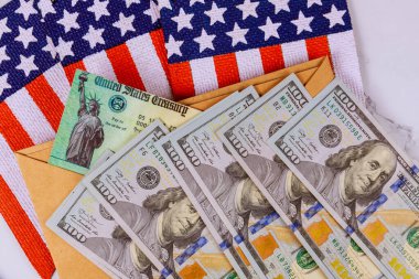 Küresel salgın Covid 19 tecrit Federal parasal yardım teşvik ABD ekonomik vergi iadesi kontrol. Amerikan bayrağında 100 dolarlık para birimi.