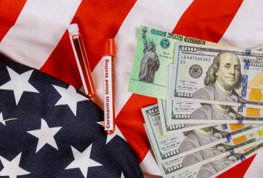 Küresel salgın Covid 19 Coronavirus tecrit maddi yardım paketi senato uyarıcısı Amerikan bayrağında Amerikan doları nakit banknotunu kontrol ediyor