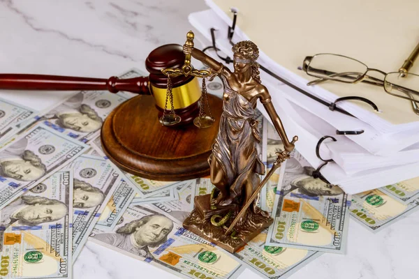 Hundred dollar of the Statue of Justice with scales with judge gavel with law documents corruption concept