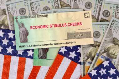 Finansal Federal STIMULUS Coronavirus Global salgını Covid 19 hükümet tarafından tecrit edilen finansal yardım çekleri Amerikan bayrağında 100 dolarlık banknotlar halinde
