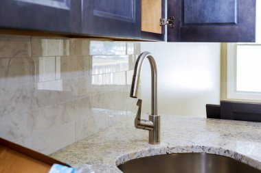 Modern tarzda yeni bir klasik mutfak. Mutfakta yeni bir seramik lavabo.