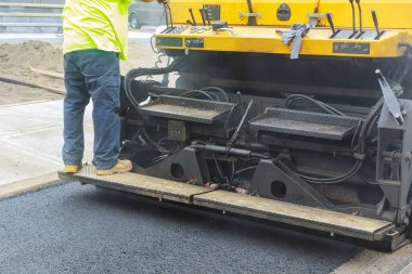 Yol yapımı sırasında asfalt kaldırım makinesi, yol yapımı ilk asfalt tabakası.