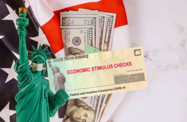 Finansal Federal STIMULUS Coronavirus Global salgını Covid 19 hükümet tarafından tecrit edilen finansal yardım çekleri Amerikan bayrağında 100 dolarlık banknotlar halinde