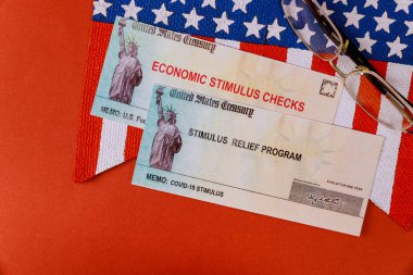 Finansal Federal STIMULUS Coronavirus Global salgını Covid 19 hükümet tarafından tecrit edilen finansal yardım çekleri Amerikan bayrağında 100 dolarlık banknotlar halinde
