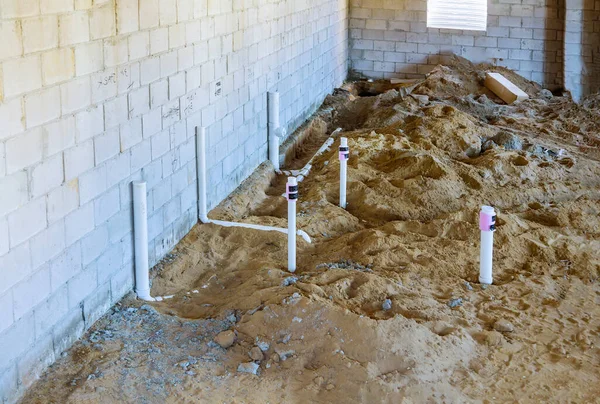 PVC drain pipes in a new house in basement assembling system of sanitary pipes in the ground — Stock Image Pvc Drain Pipes New House Basement Assembling System Sanitary Pipes Stock Image