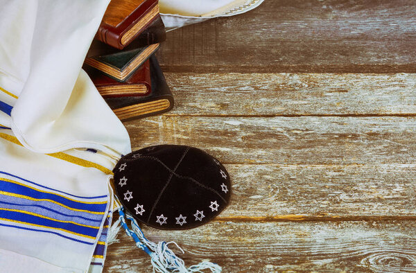 Jewish ritual with kippah and talit praying in the Jewish hebrew prayer book on a synagogue