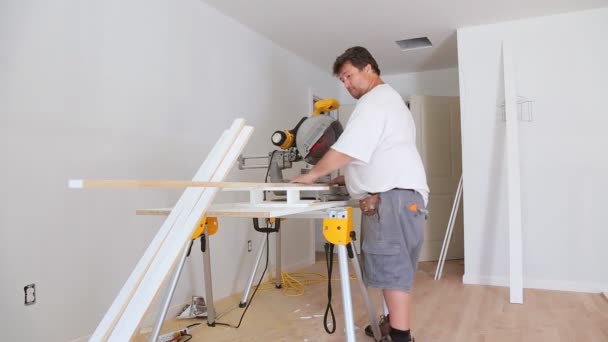 Charpentier travaillant à l'aide de scie circulaire rotative scie à bois de coupe plinthe — Video