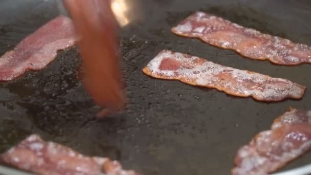 Crispy hot fried of bacon pieces being fried in a pan — Stock Video