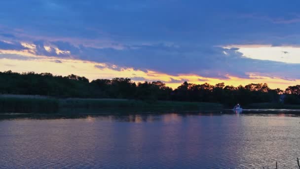 Motorboot rast bei Sonnenuntergang durch den Fluss — Stockvideo