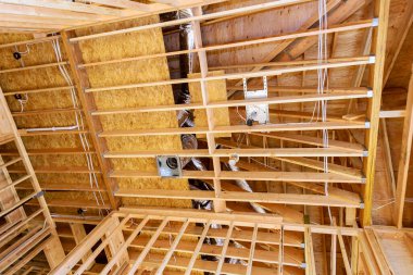 İnşaat kirişlerinin altındaki ahşap çerçeveli ev.