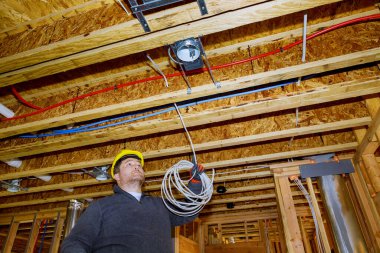 Elektrik tesisatçısıyla çalışan elektrikçi yeni evinde montaj yapıyor