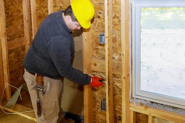 Yeni ev inşaatının duvarlarında elektrik kabloları var.