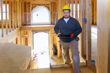 İnşaat müfettişi elinde tabletle yeni bir eve bakıyor.