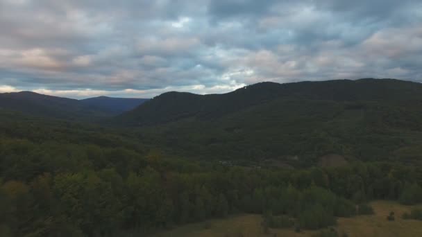 Montanhas e uma vista da altura do vale com casas no fundo de um dia ensolarado de verão. Topo da montanha e céu azul — Vídeo de Stock