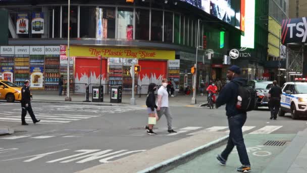 По нью-йоркскому Манхэттену ходят люди в масках для защиты лица во время глобального коронавируса COVID-19 — стоковое видео