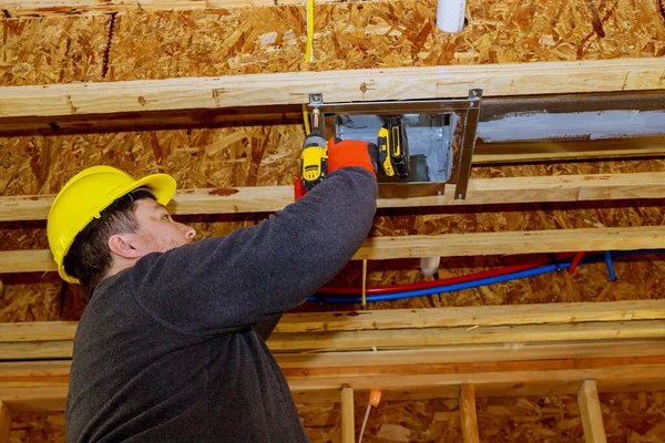 天井鋼屋根構造換気システム上の男性技術者が空気加熱冷却システムを搭載 — ストック写真