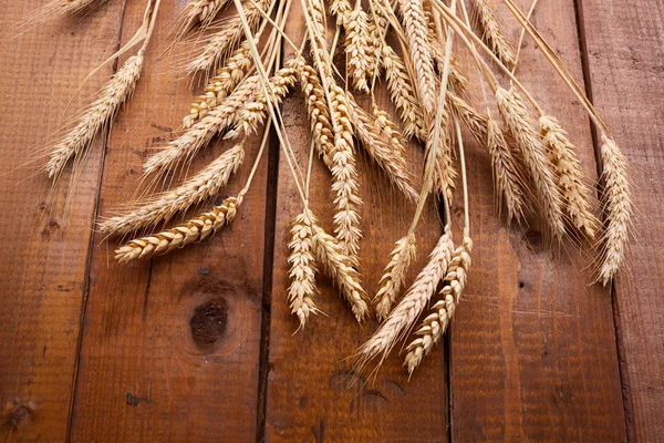 Колоски пшениці на дерев'яному фоні — стокове фото