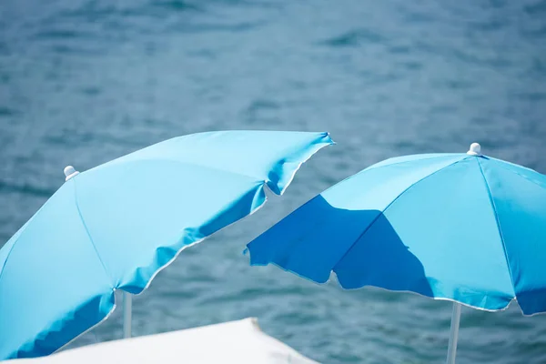 Blauwe strand parasols Stockfoto