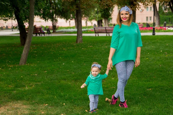 mother and daughter walking on the grass