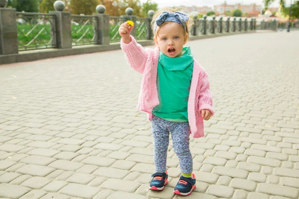 Malá dívka pózuje s květinou — Stock fotografie