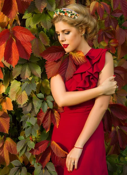 Όμορφο κορίτσι με κόκκινο φόρεμα ποζάρουν με φόντο φθινοπωρινά lea — Φωτογραφία Αρχείου