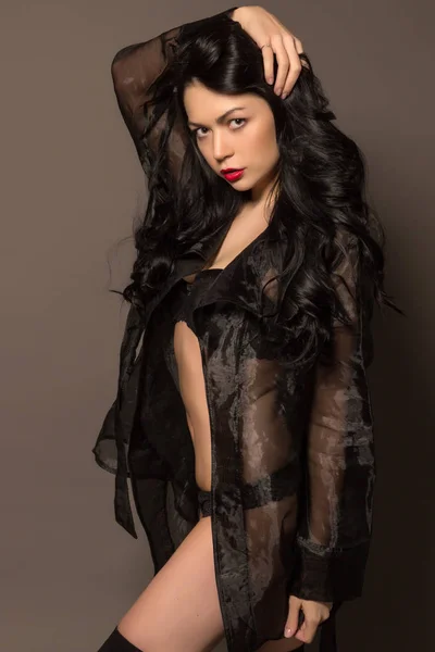 Mooie sexy brunette in zwarte lingerie en neglige poseren — Stockfoto
