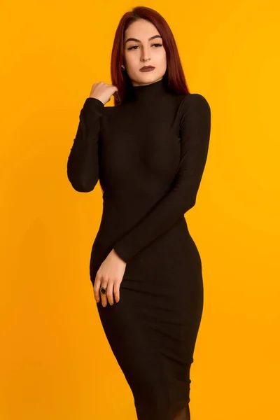 Schönes Mädchen in einem langen schwarzen Kleid posiert — Stockfoto