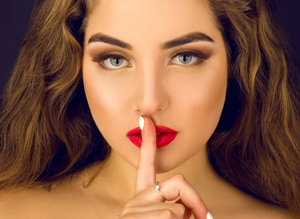 Retrato de moda de uma menina com um dedo pressionado em seus lábios — Fotografia de Stock