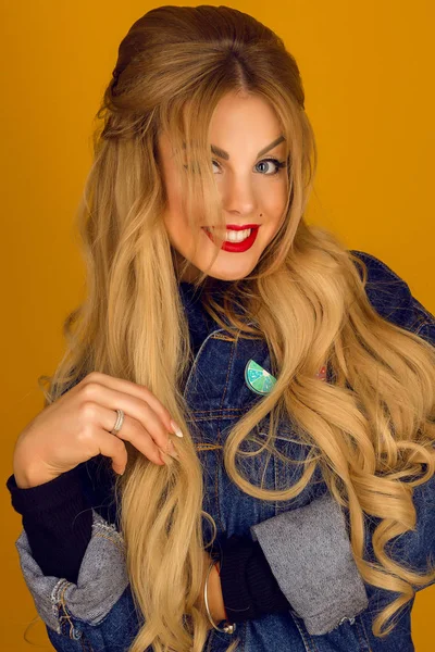 Schöne Blondine mit langen Haaren in Jeansjacke posiert — Stockfoto