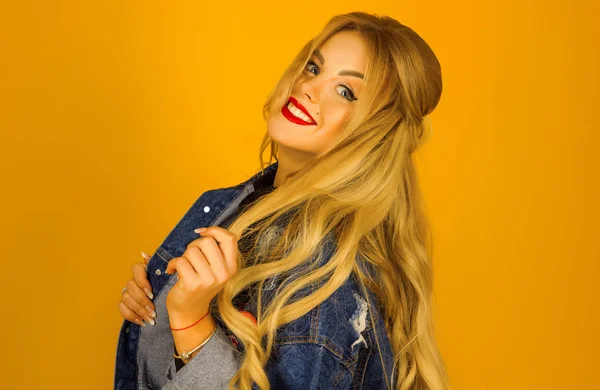 Beautiful blonde with long hair in a denim jacket posing — Stock Photo, Image