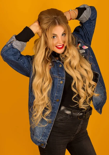 Hermosa rubia con el pelo largo en una chaqueta de mezclilla posando — Foto de Stock