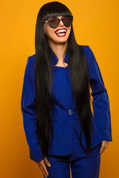 Sorridente ragazza con i capelli lunghi neri in abito blu in posa — Foto Stock