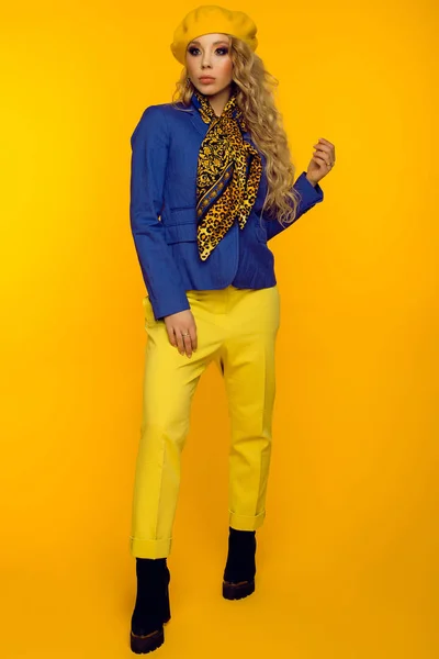 Modefoto. Blondine mit gelber Baskenmütze in blauer Jacke und gelbem Hemd — Stockfoto