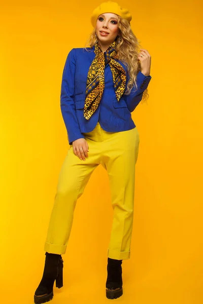 Modefoto. Blondine mit gelber Baskenmütze in blauer Jacke und gelbem Hemd — Stockfoto