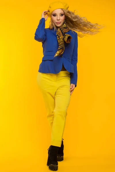 时尚照片。金发女郎穿着蓝色夹克和 yel 的黄色贝雷帽 — 图库照片