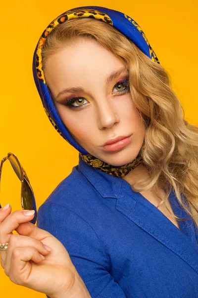 Modeporträt einer schönen Blondine in einem blauen Halstuch und einem — Stockfoto
