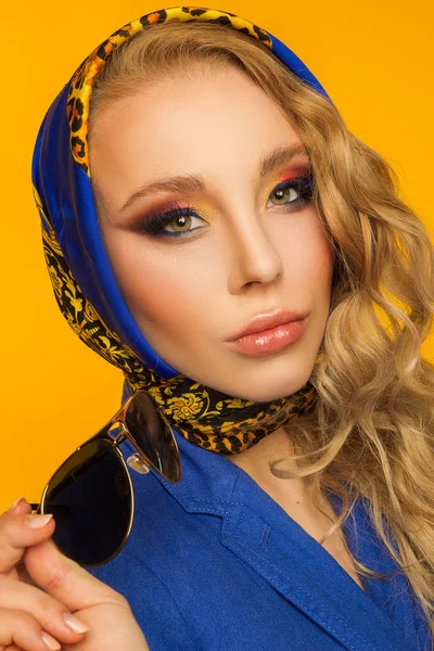 Retrato de moda de uma bela loira em um lenço azul e um — Fotografia de Stock