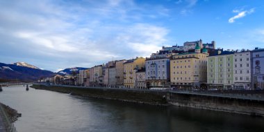 Salzburg nehir kıyısında Salzach nehri ve Hohensalzburg şatosuyla güneşli bir günde.